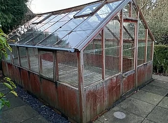 Greenhouse in garden before removal